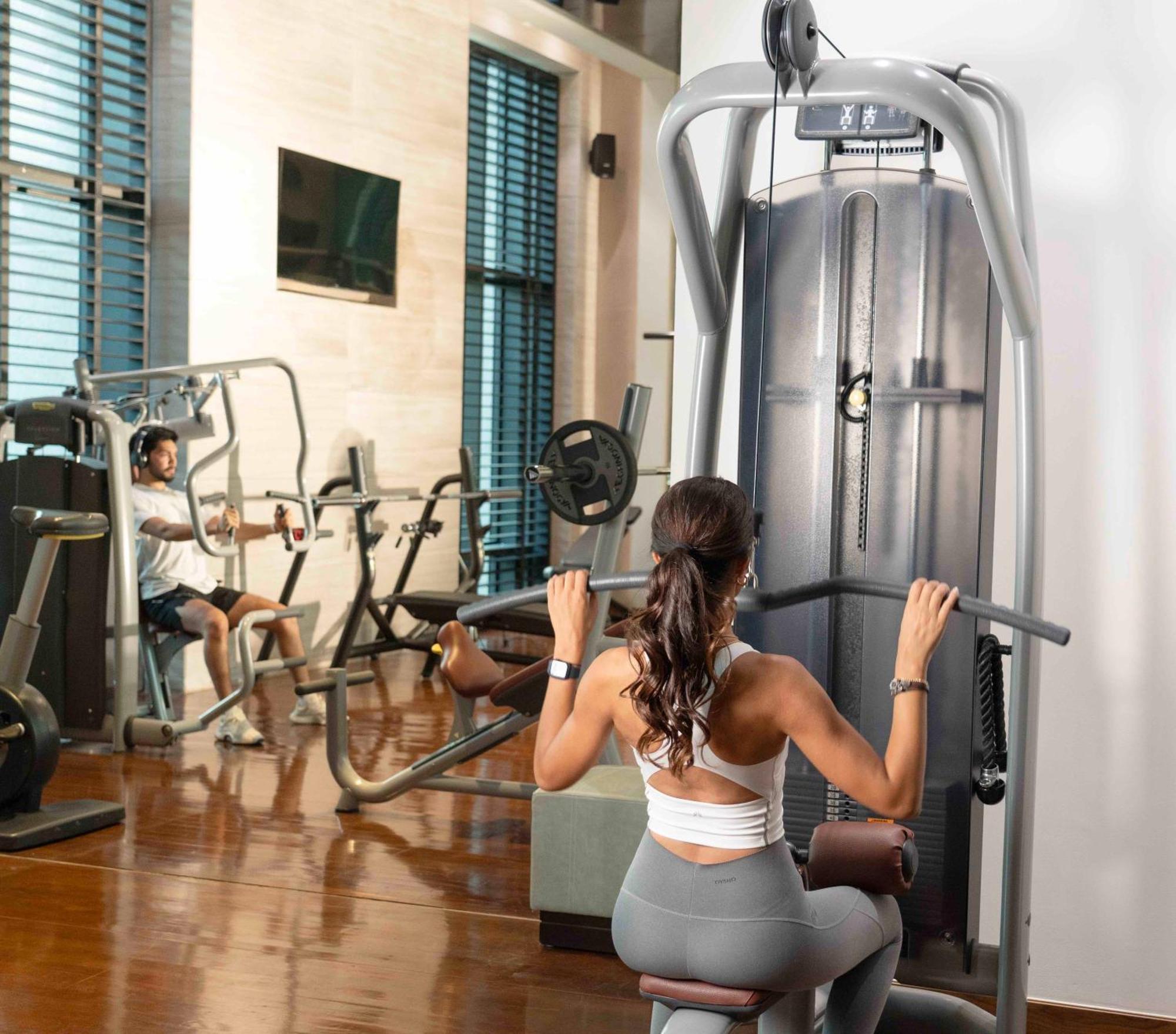 Fairmont Riyadh Exteriör bild A woman using a lat pulldown machine