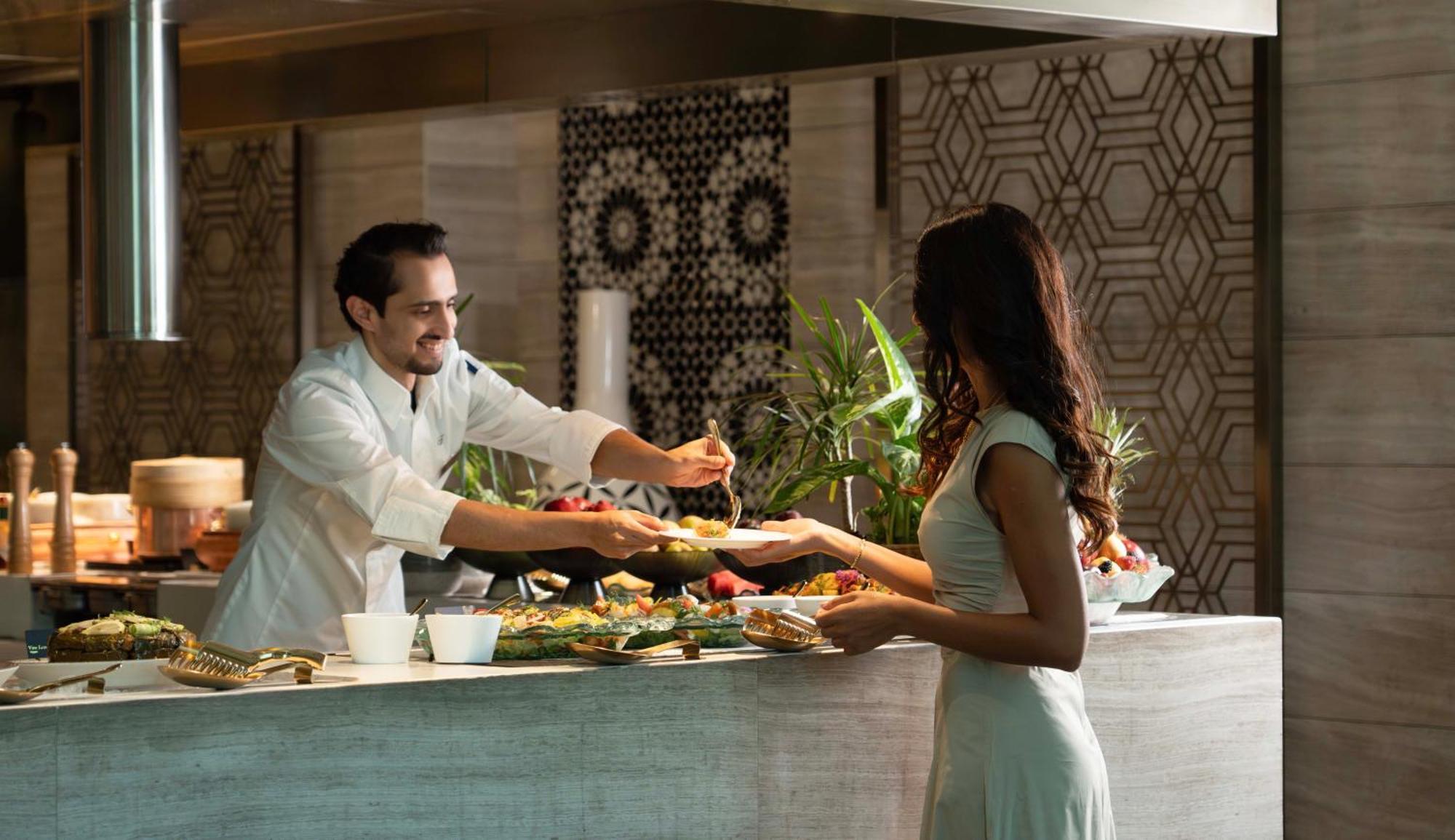 Fairmont Riyadh Exteriör bild A chef serving a guest at the buffet